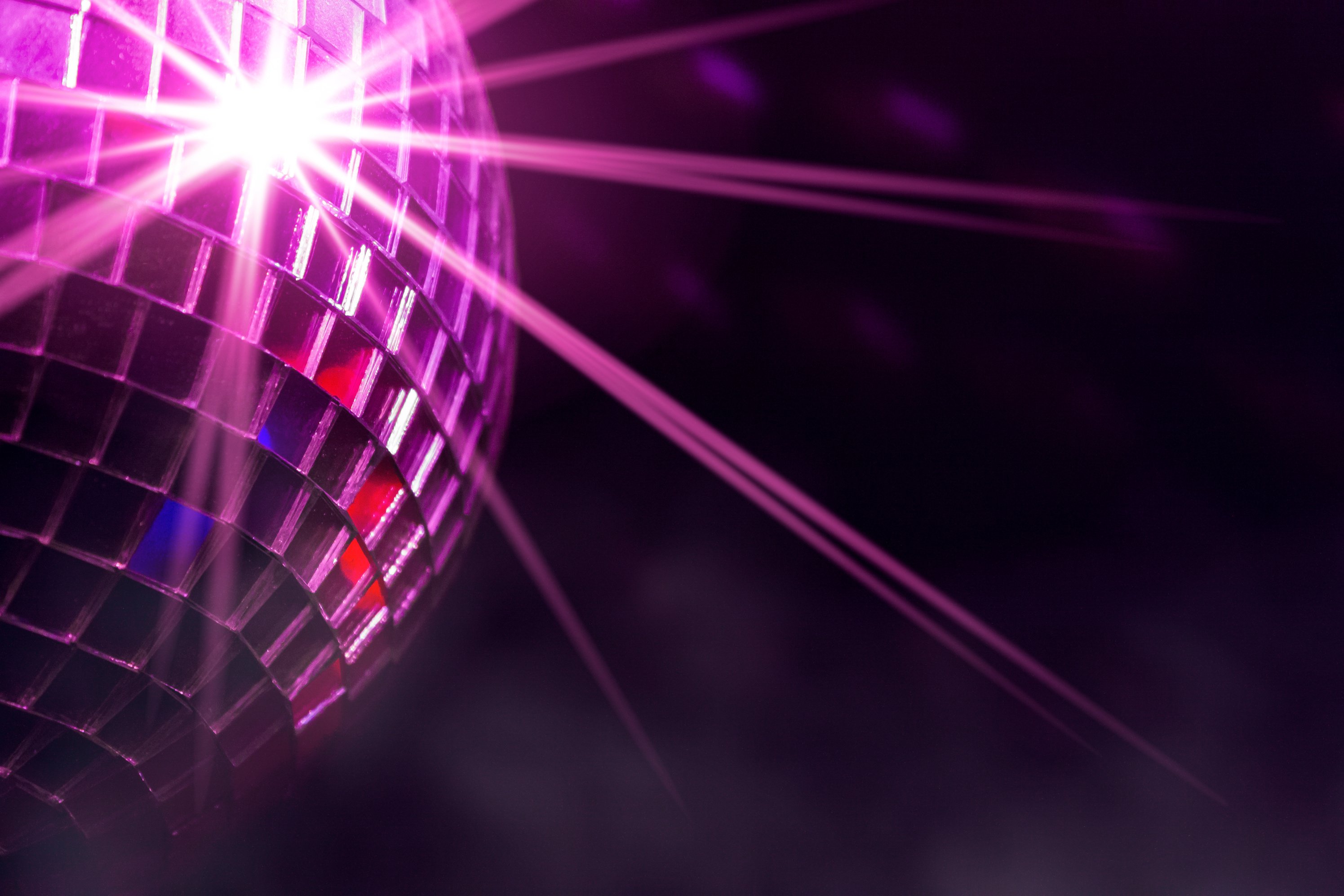 Disco ball with violet star burst and fog in club